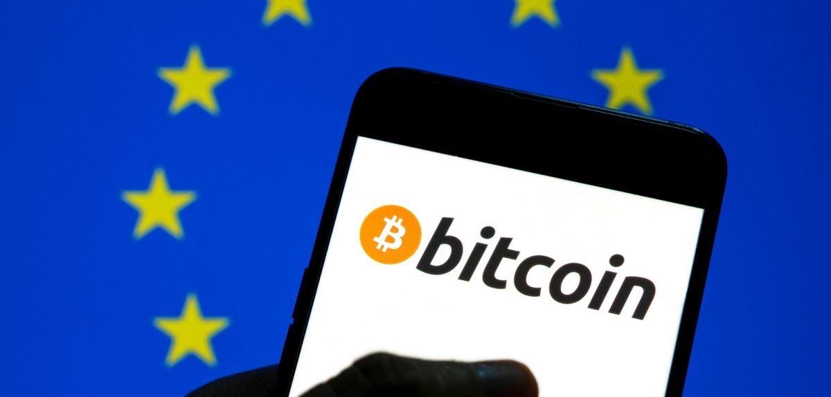 Bitcoin-Logo vor einer EU-Flagge