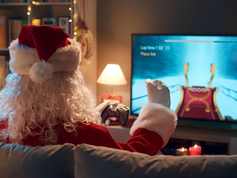 Weihnachtsmann spielt vor einem Fernseher