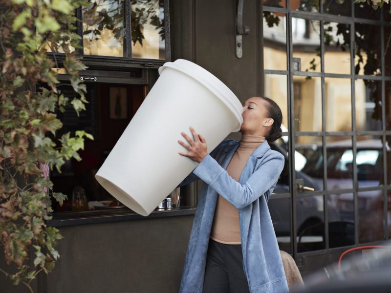 Frau mit riesigem Kaffeebecher