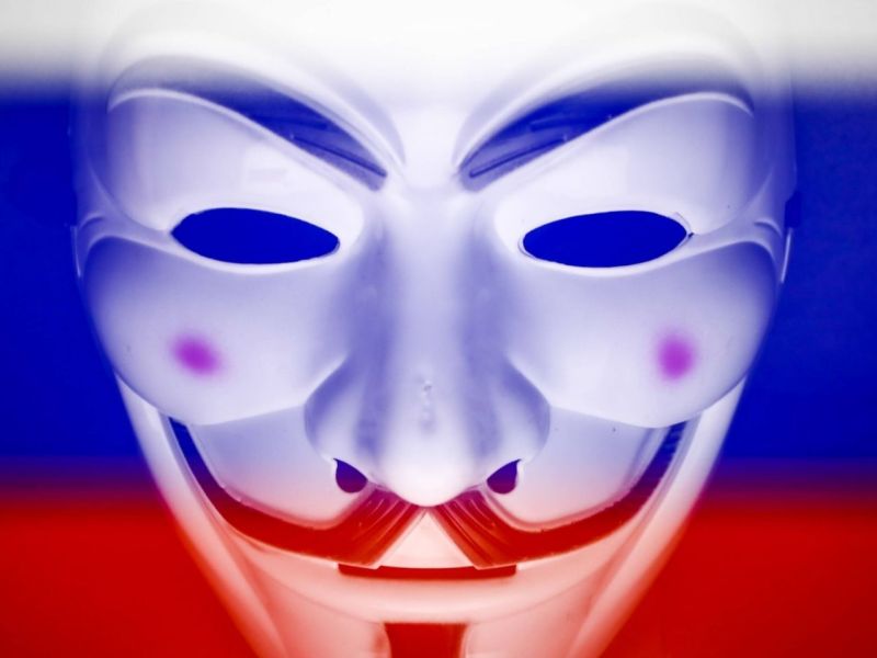 Anonymous-Maske vor einer russischen Flagge.