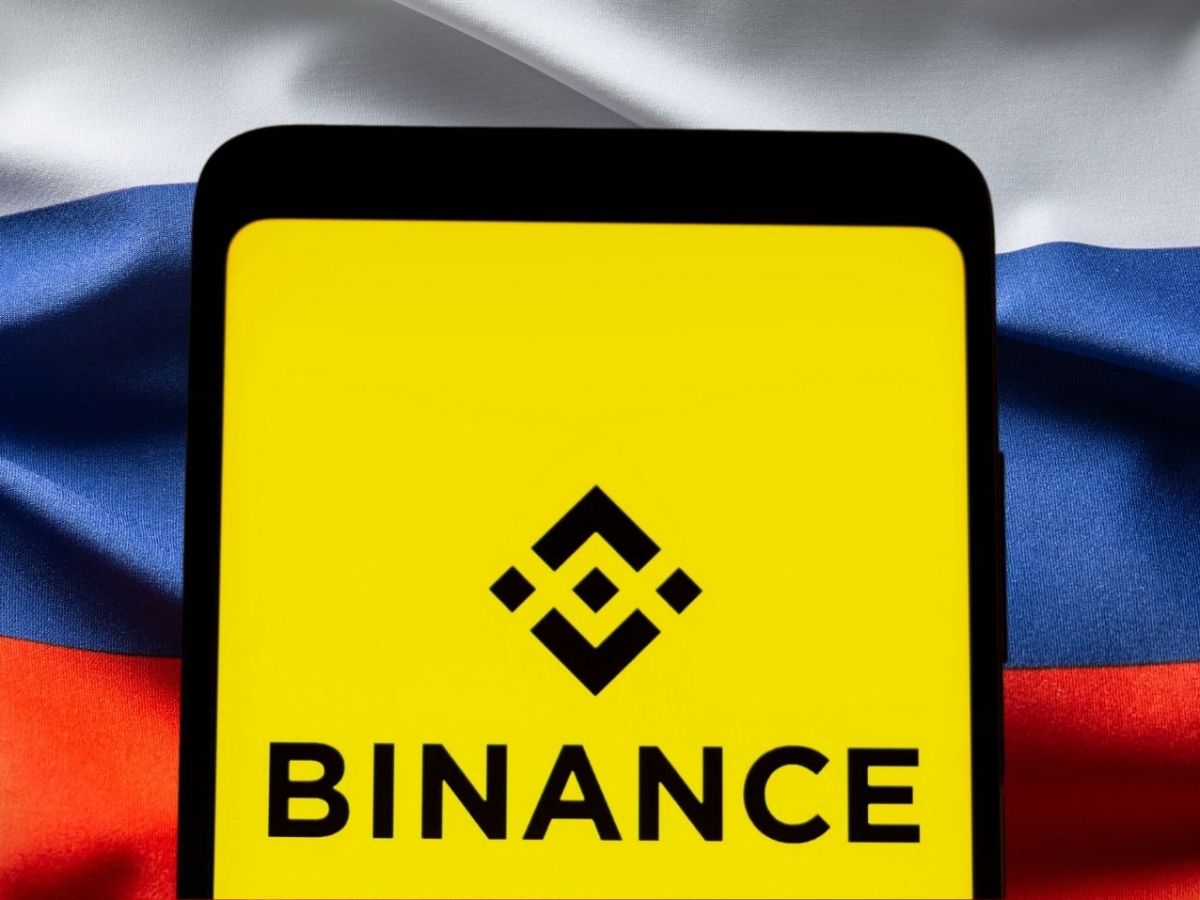 Binance-Logo vor einer Russland-Flagge