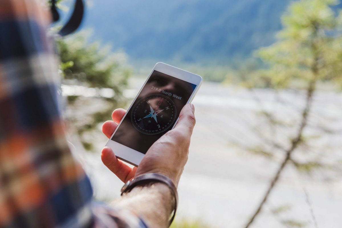 Wanderer mit Kompass-App auf Smartphone