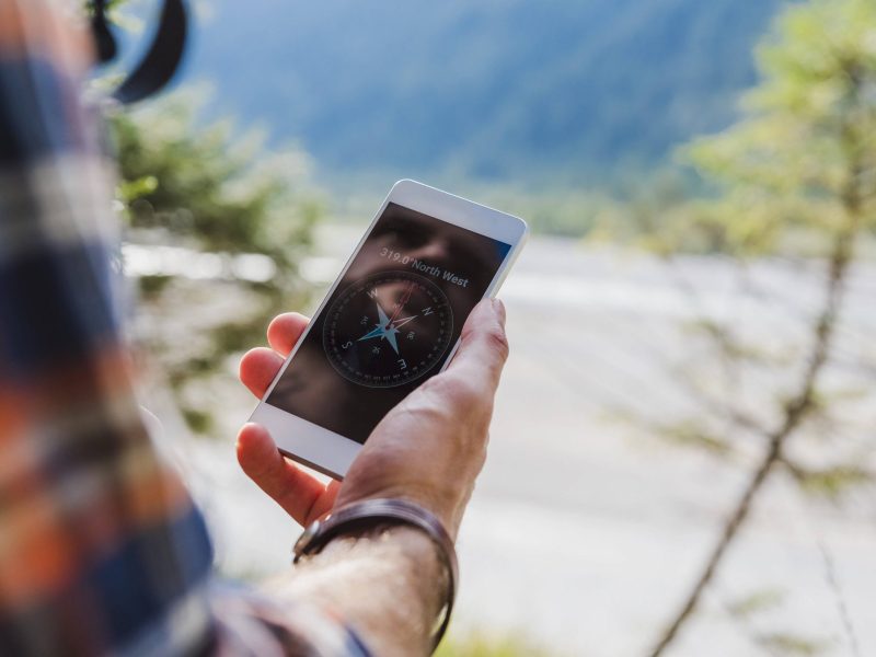 Wanderer mit Kompass-App auf Smartphone