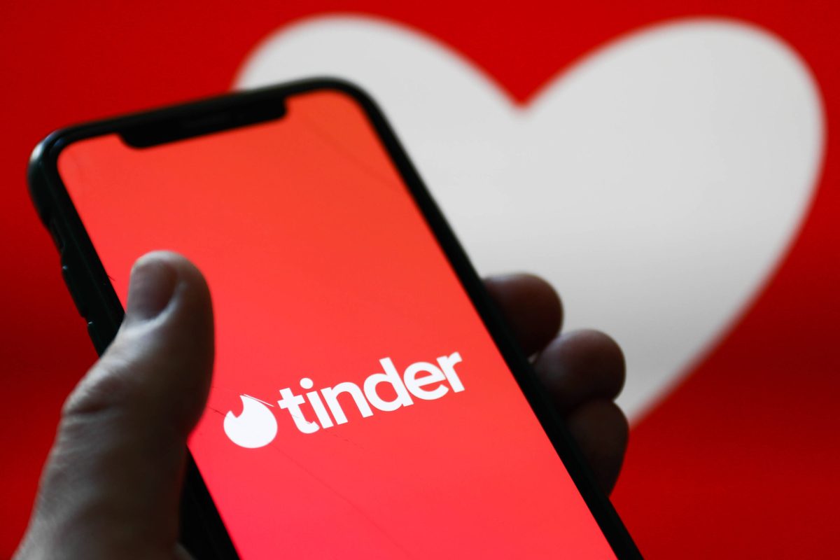 Tinder-App auf Smartphone vor Herzsymbol