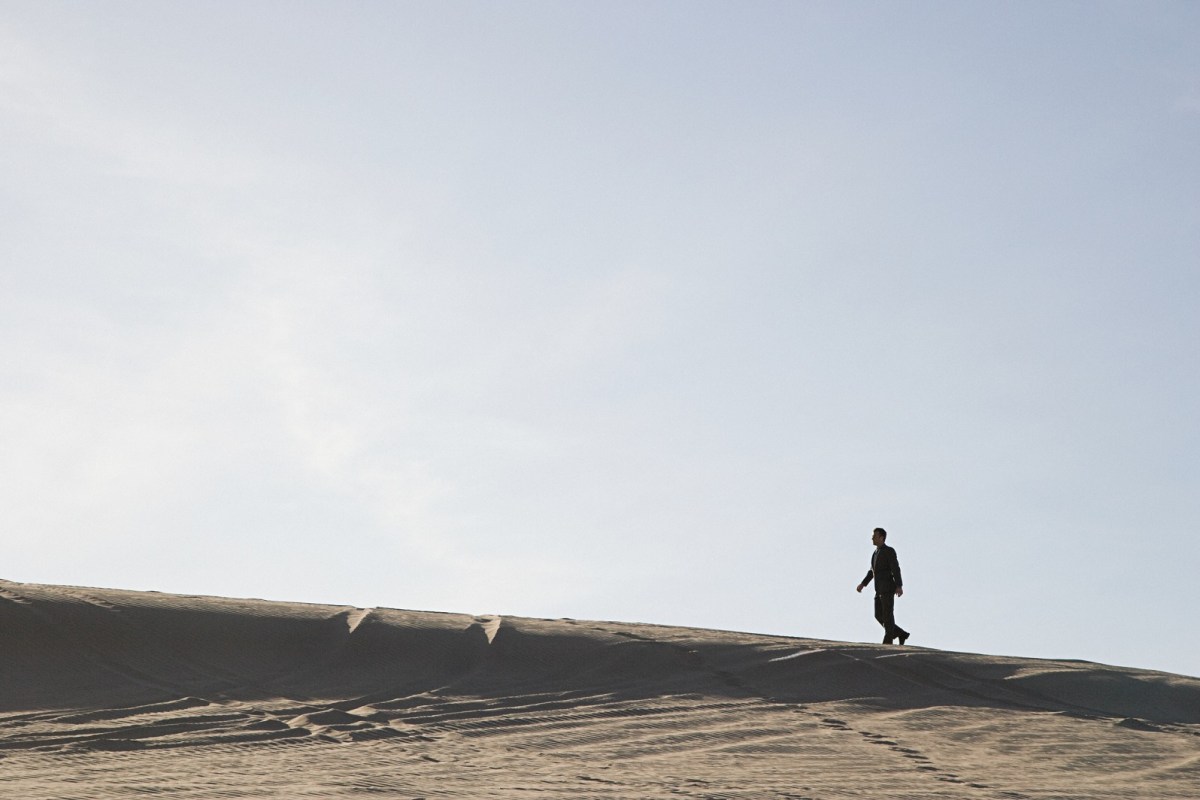 Mann läuft auf Sanddüne