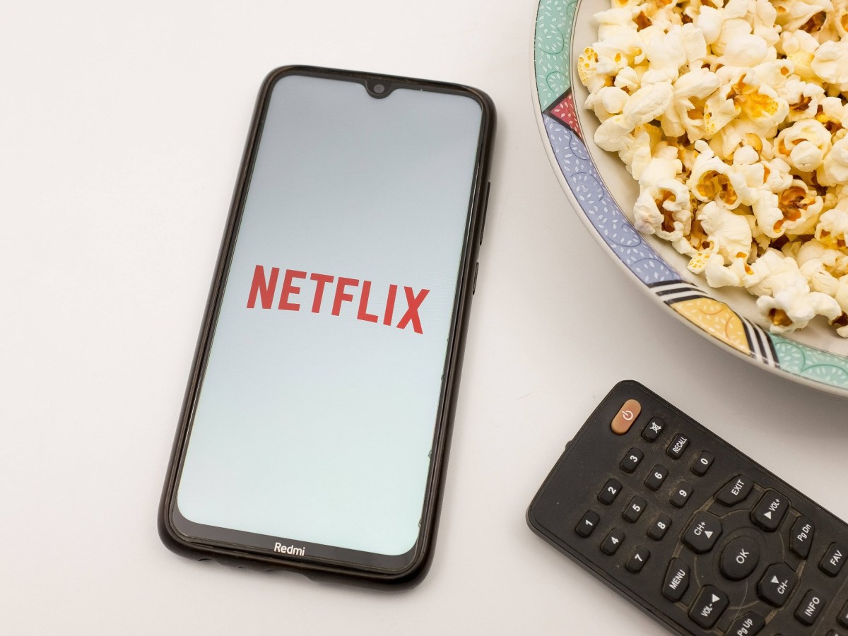 Netflix App auf Handy mit Popcorn und Fernbedienung