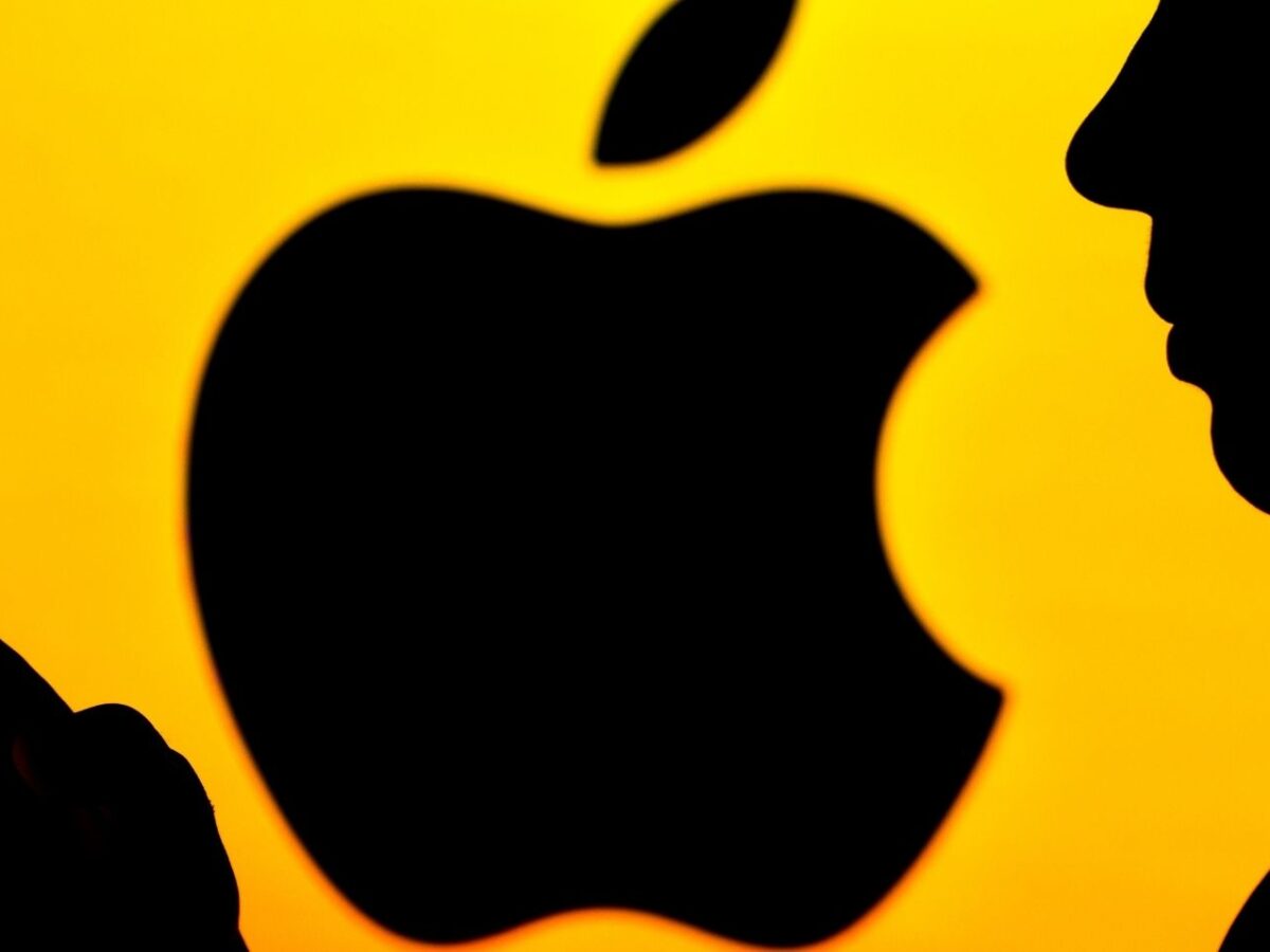 Frau mit iPhone vor Apple-Logo