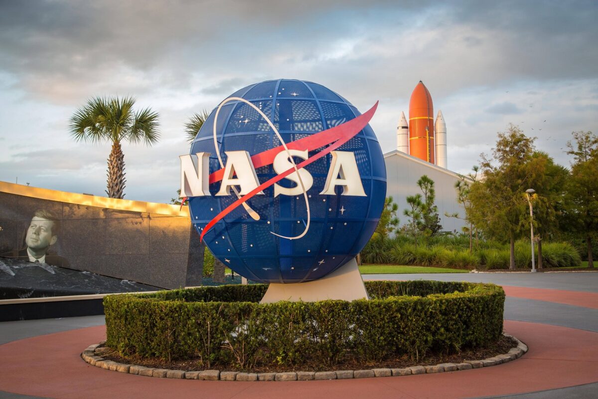 Logo der Nasa vor Kennedy Space Center, Weltraumbahnhof, hinten Rakete, Cape Canaveral, Merritt Island, Florida