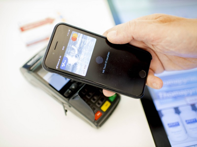 Person zahlt mit Smartphone