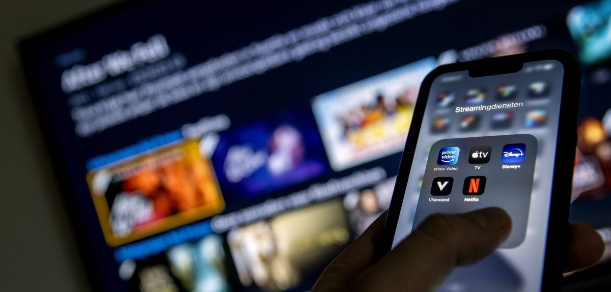 Smartphone mit Streaming-Apps, im HIntergrund ein TV.