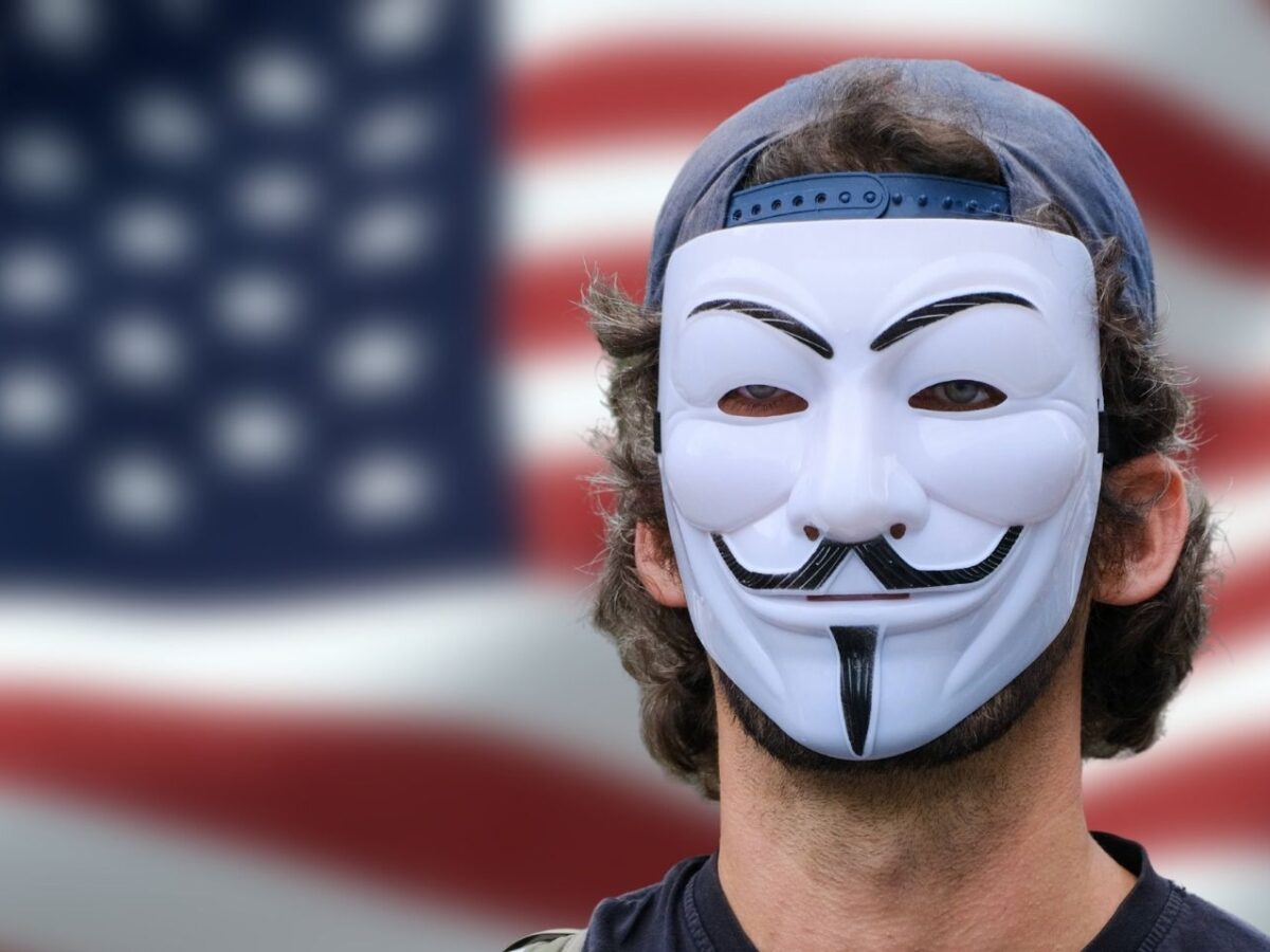 Anonymous-Maske vor der US-Flagge.