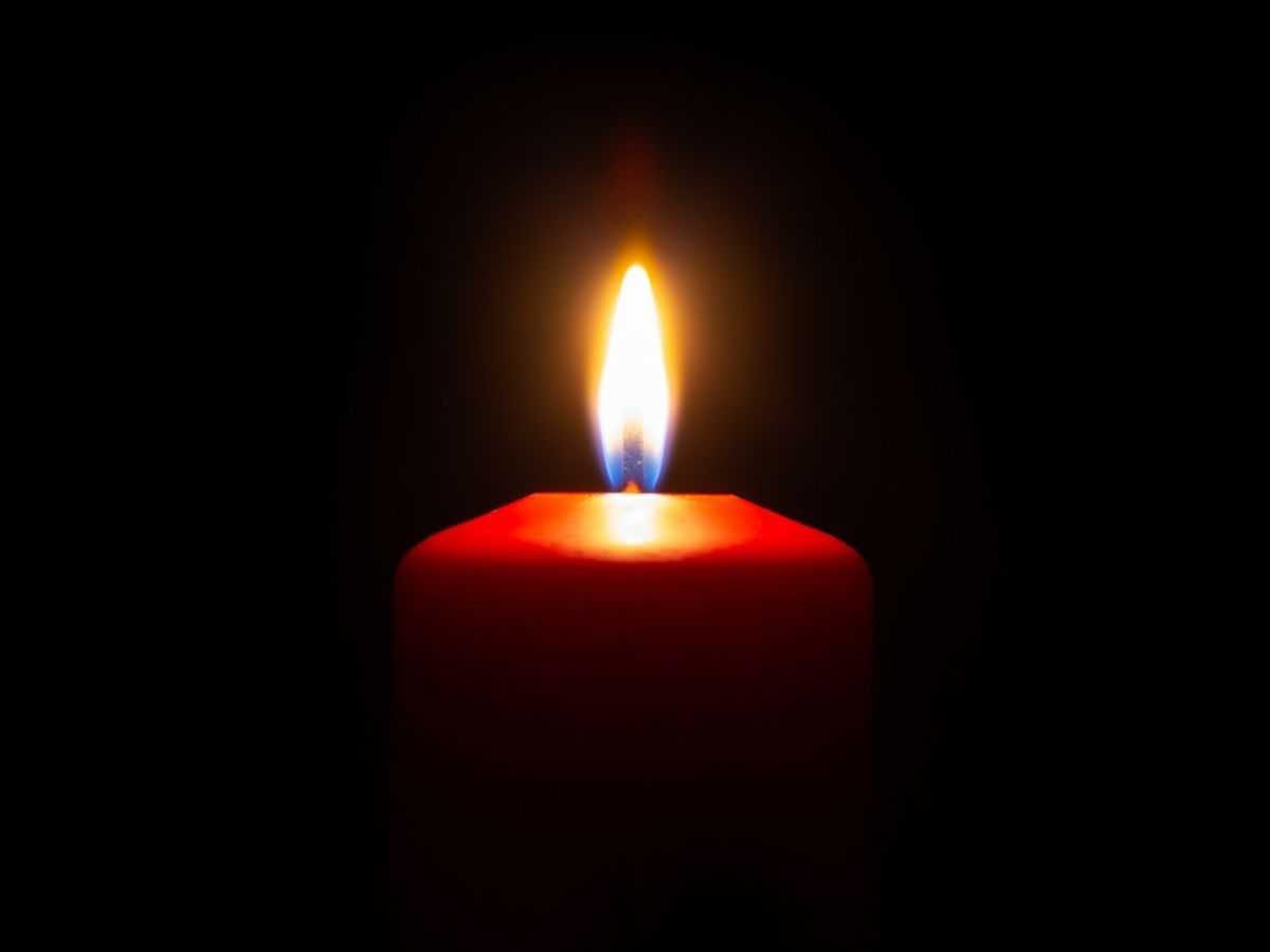 Brennende Kerze in der Dunkelheit.