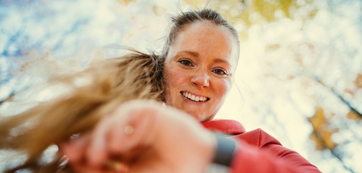 Frau schaut auf Fitness-Uhr