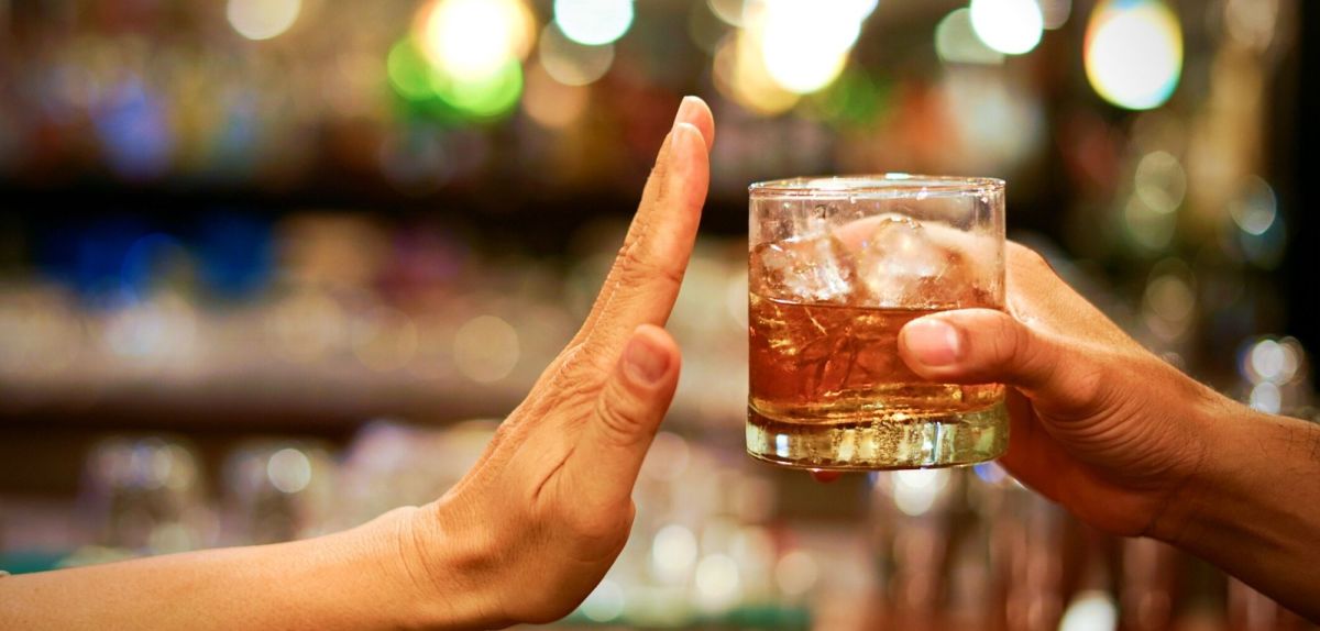 Hand lehnt Glas mit Alkohol ab
