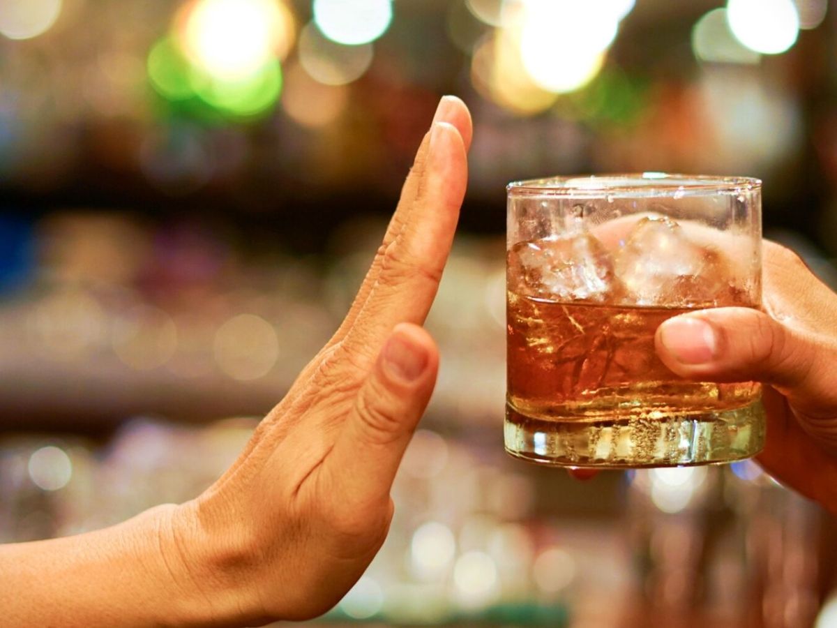 Hand lehnt Glas mit Alkohol ab