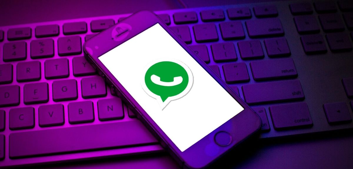 Handy mit WhatsApp Logo liegt auf Tastatur