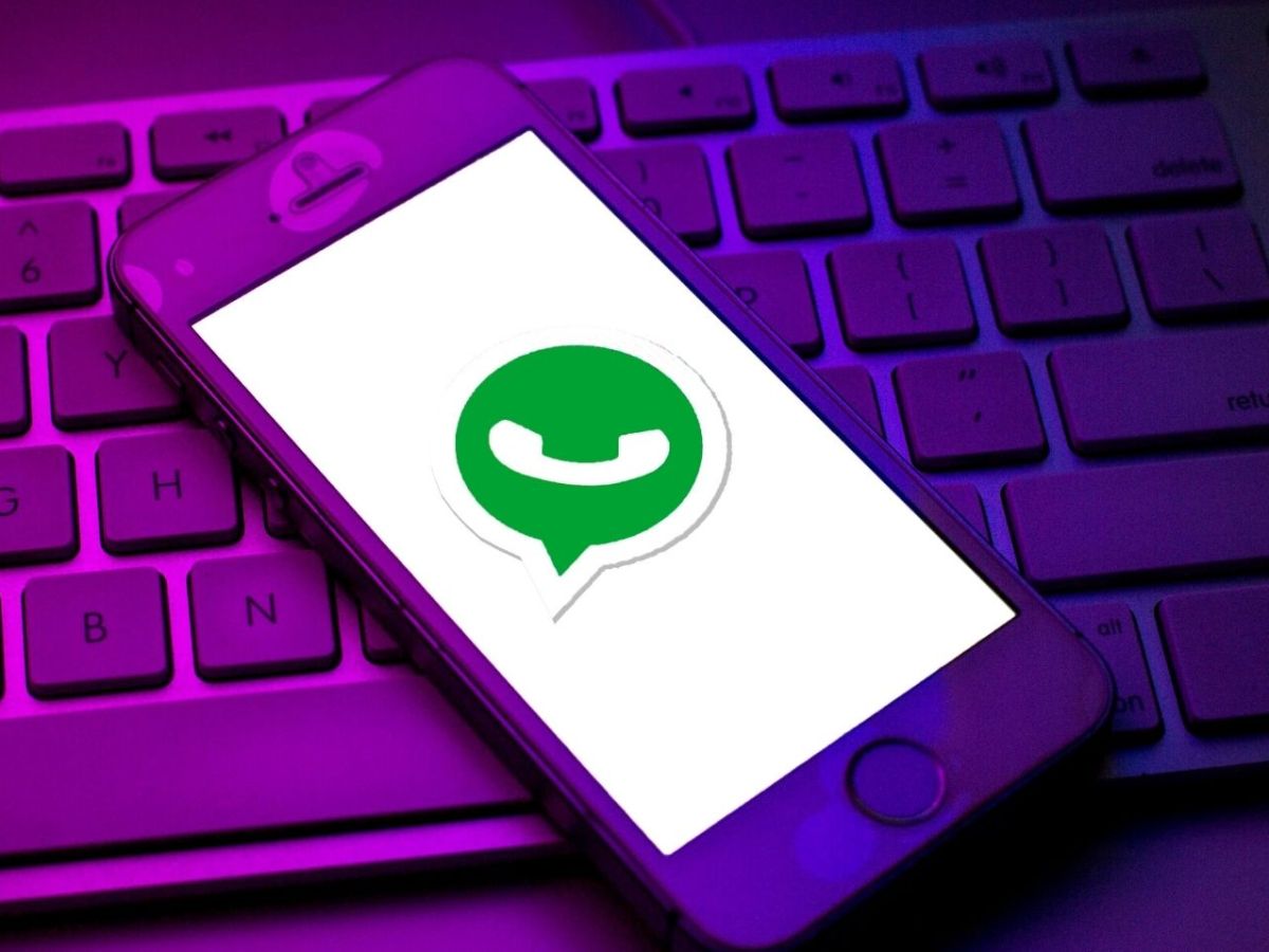 Handy mit WhatsApp Logo liegt auf Tastatur