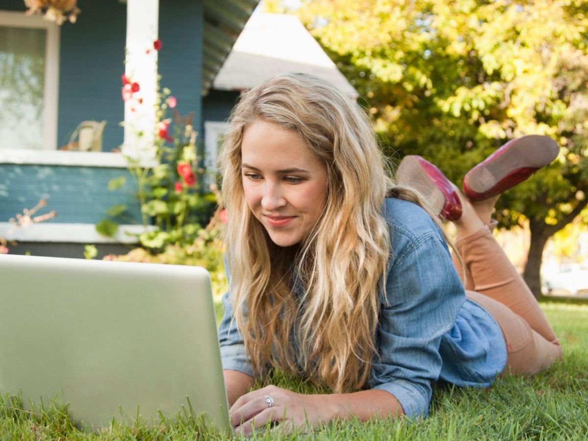 Frau mit Laptop im Garten