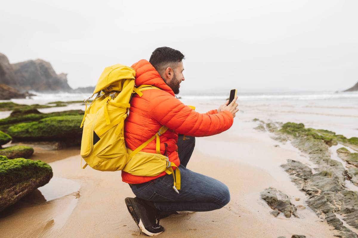 Outdoor-Handy wird von Mann zum Fotografieren an Küste genutzt