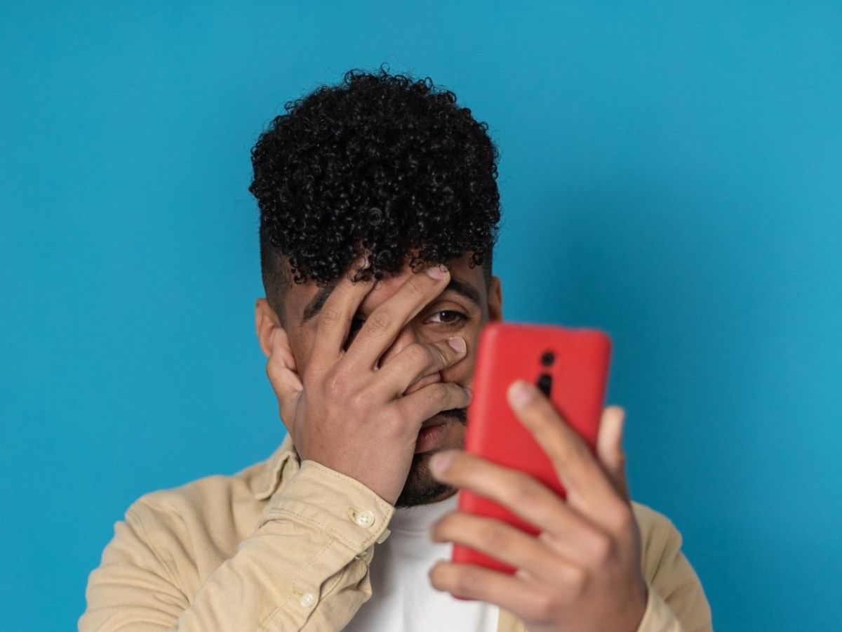 Mann schaut ängstlich auf sein Smartphone
