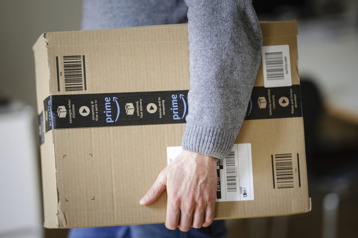 Mann trägt Amazon Prime-Paket unter dem Arm