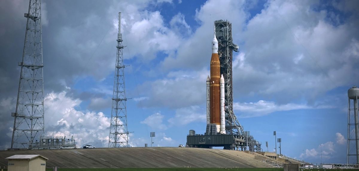 Space Launch System (SLS)-Rakete der NASA mit dem Orion-Raumschiff an Bord auf einer mobilen Trägerrakete, als sie aus dem Vehicle Assembly Building zum Startkomplex 39B im Kennedy Space Center rollt