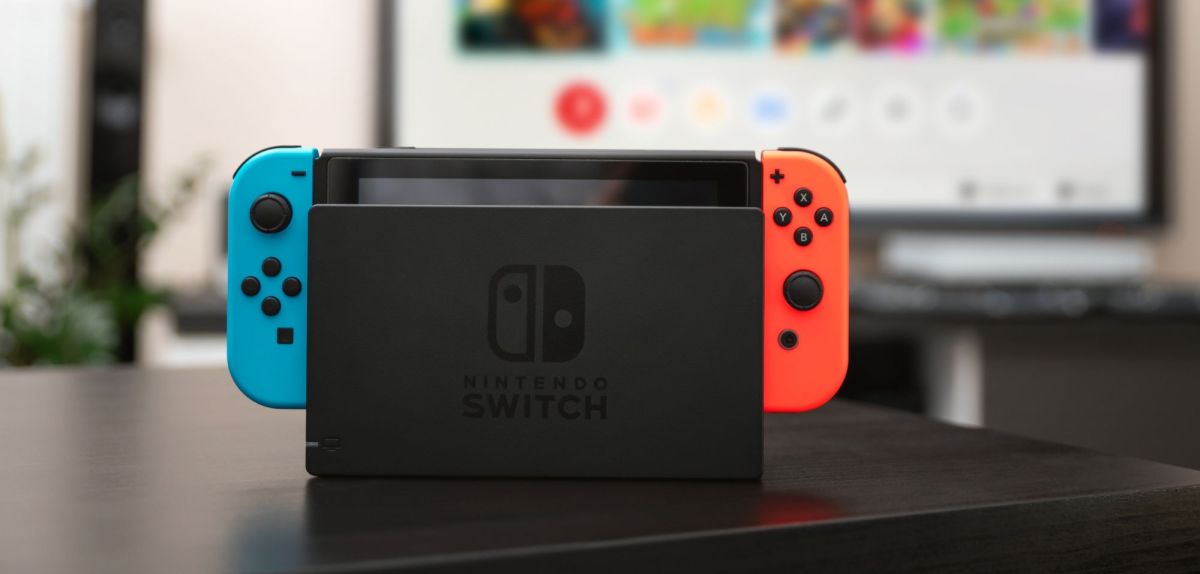 Nintendo Switch in Docking-Station auf einem Tisch.