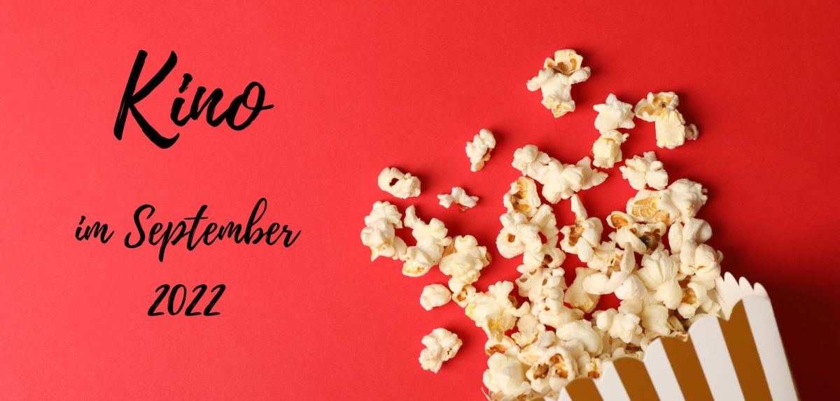 Roter Hintergrund, verschüttetes Popcorn und Schriftzug "Kino im September 2022"