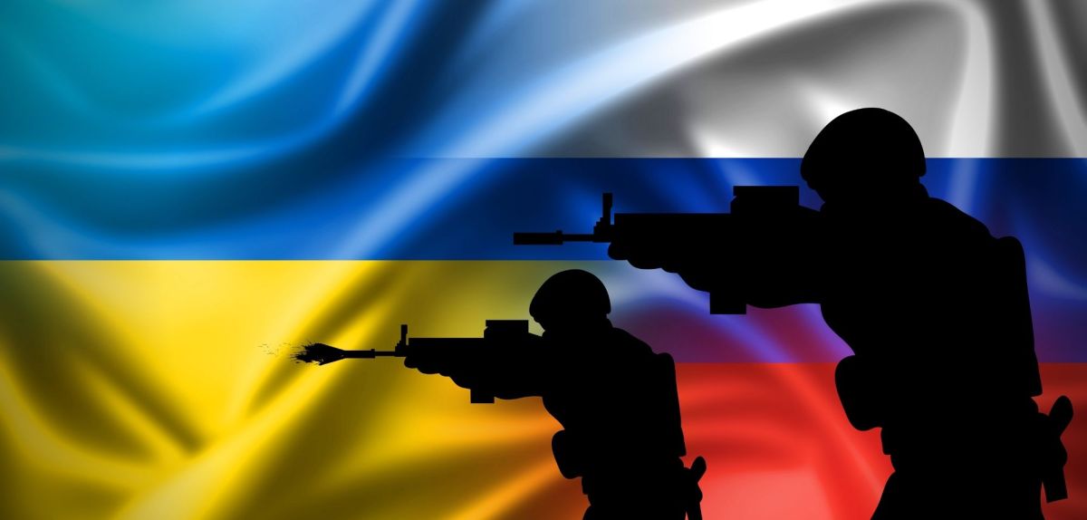 Ukrainische und Russische Flaggen nebeneinander – Soldaten im Vordergrund