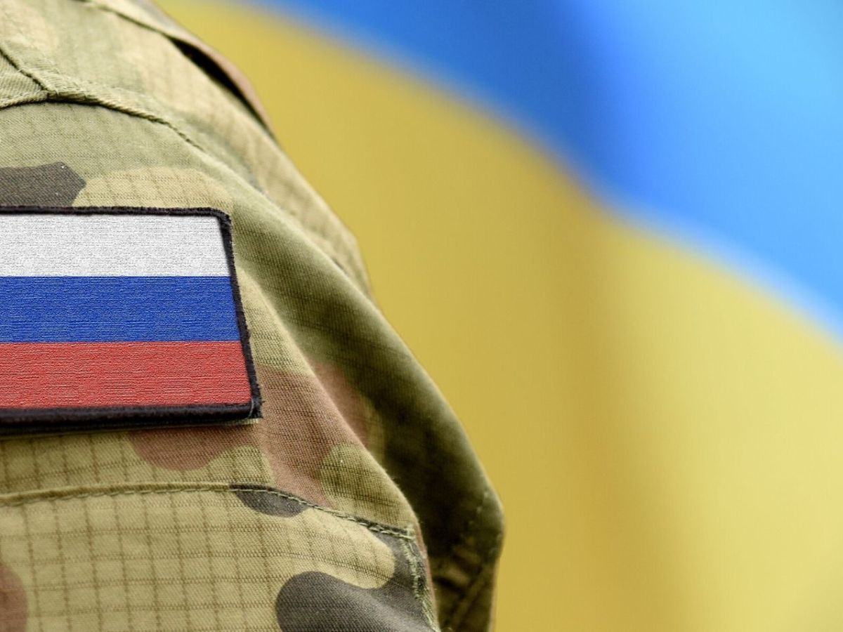 Russischer Soldat vor einer Ukraine-Flagge