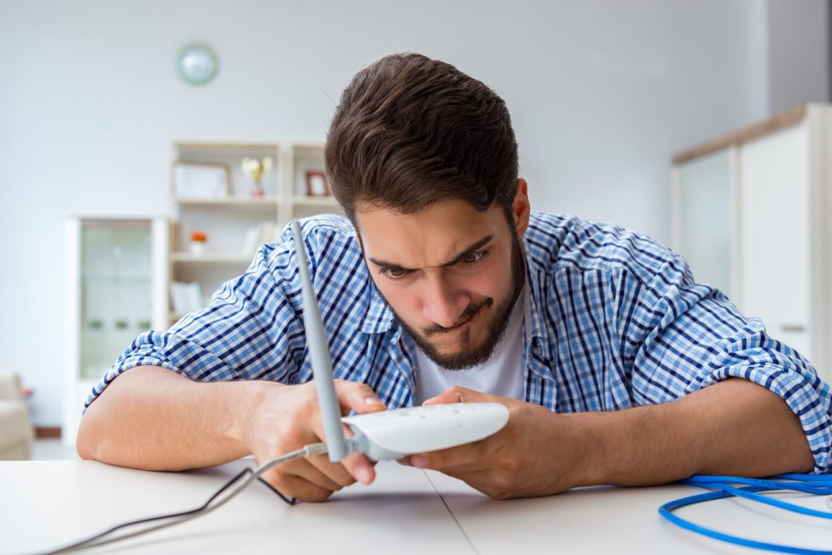 Mann hält WLAN-Router in der Hand