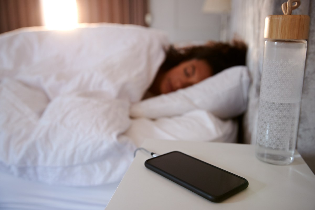 Frau im Bett mit Handy