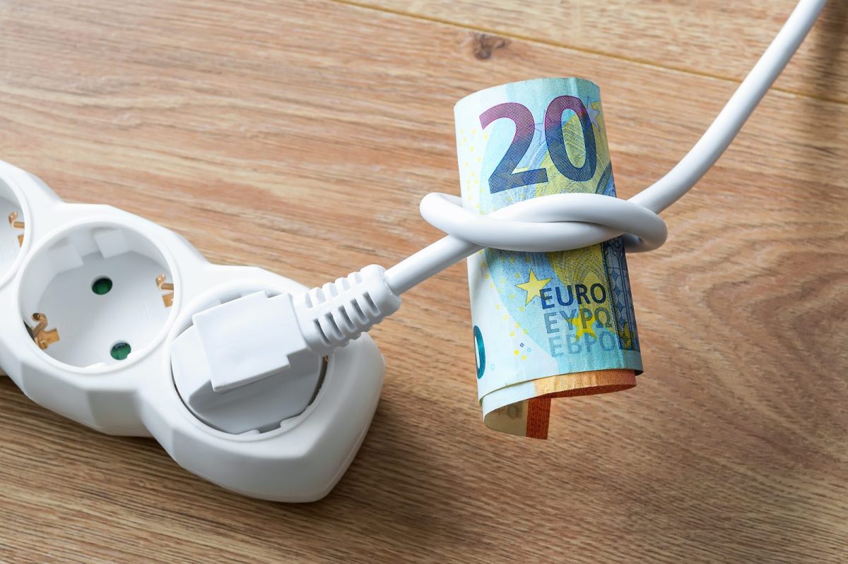 Stecker in der Steckdose und ein 20-Euro-Schein