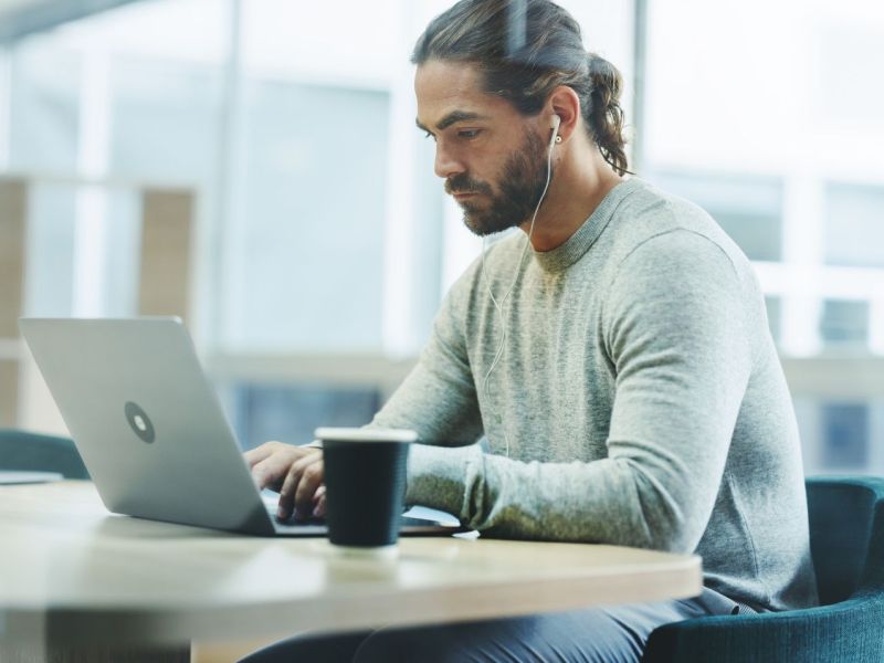 Mann sitzt am Laptop