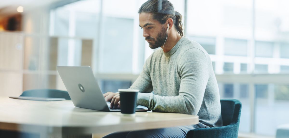 Mann sitzt am Laptop