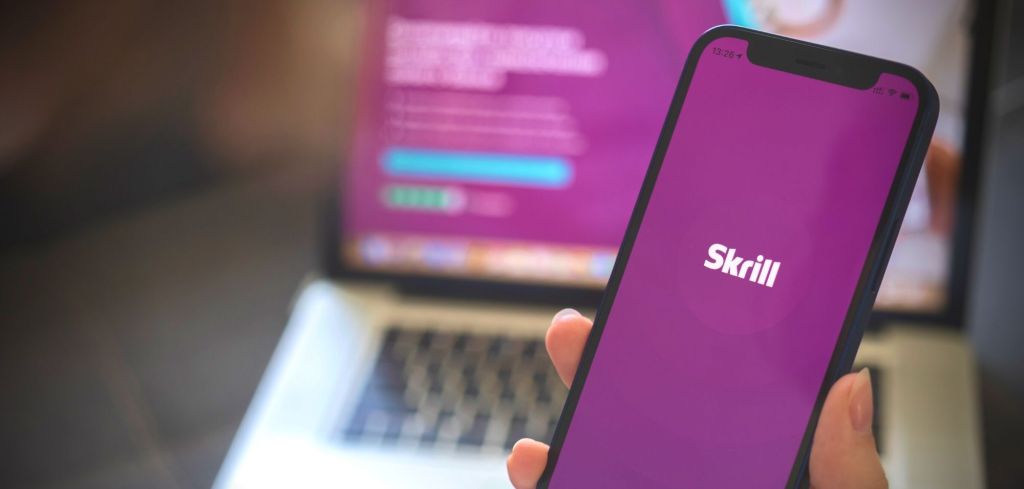 Skrill-Anwendung auf Smartphone und Laptop