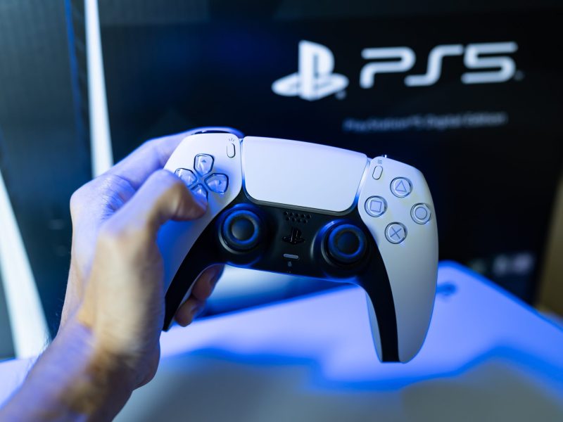 PS5-Controller wird vor die Konsole gehalten