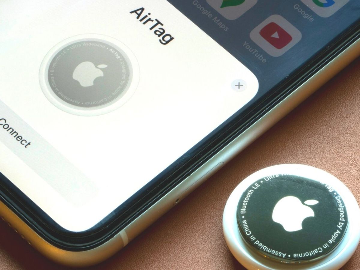 Ein Apple AirTag neben einem iPhone.
