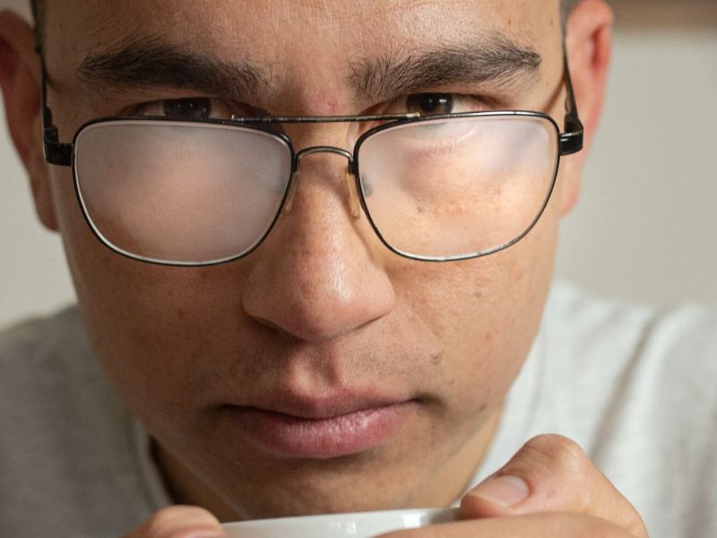 Mann, dessen Brille beschlagen ist.