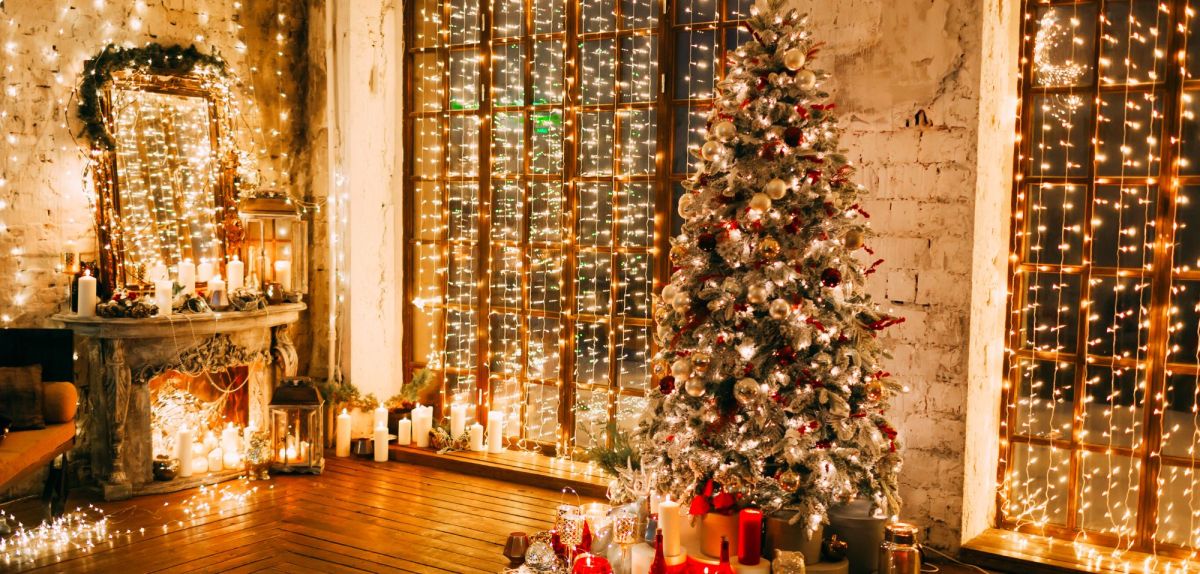 Lichterketten und Weihnachtsbaum in großem Raum