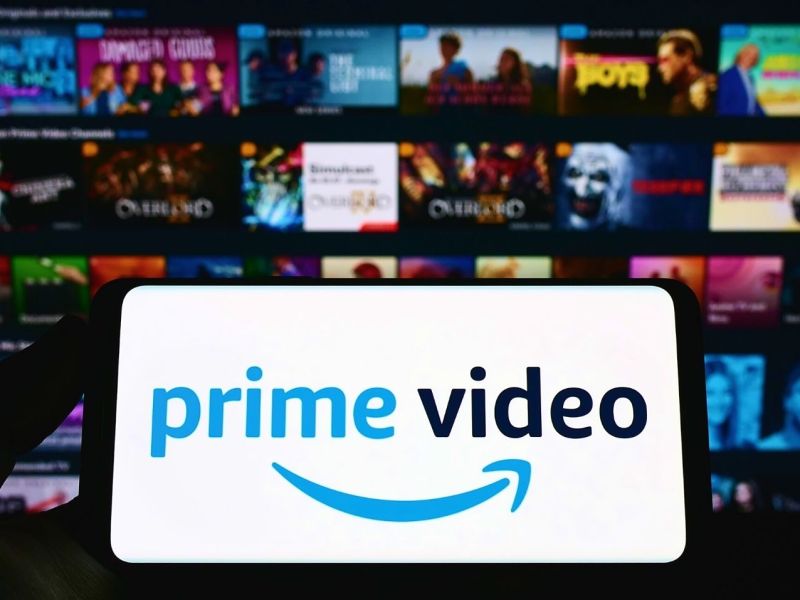 Handy-Display mit dem Logo von Amazon Prime Video, im Hintergrund zahlreiche Filmkacheln.
