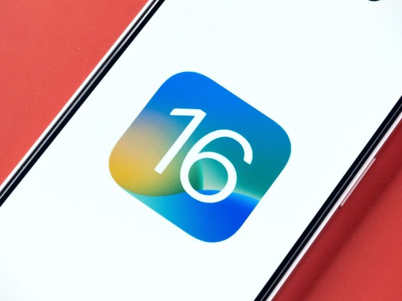 Handy mit dem Logo für iOS 16 auf dem Display.