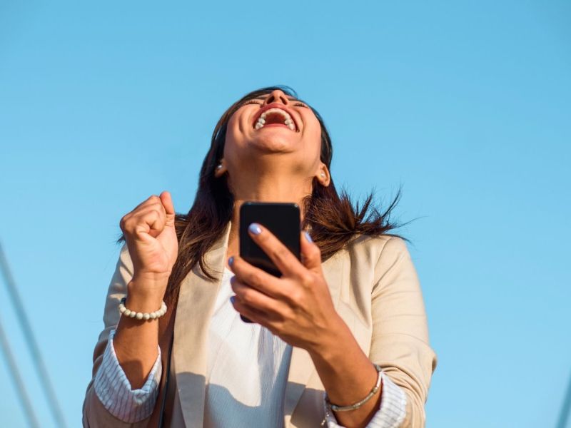 Frau mit Smartphone freut sich