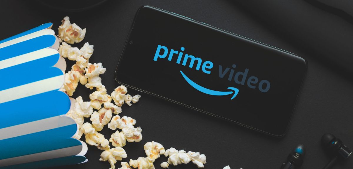 Tüte Popcorn, daneben ein Handy mit dem Logo von Amazon Prime Video.