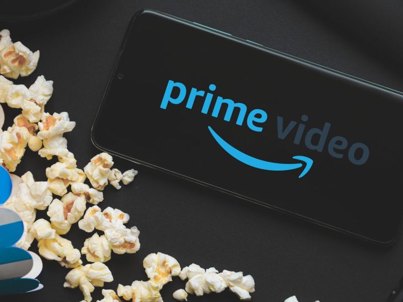Tüte Popcorn, daneben ein Handy mit dem Logo von Amazon Prime Video.