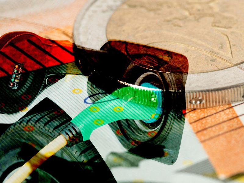 Elektroauto überlappt von einem Transparenten Bild von Geldscheinen und -münzen