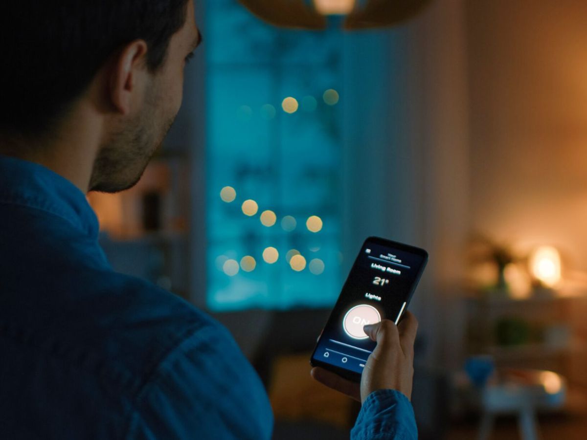 Mann mit Smartphone in einem schwach beleuchteten Raum