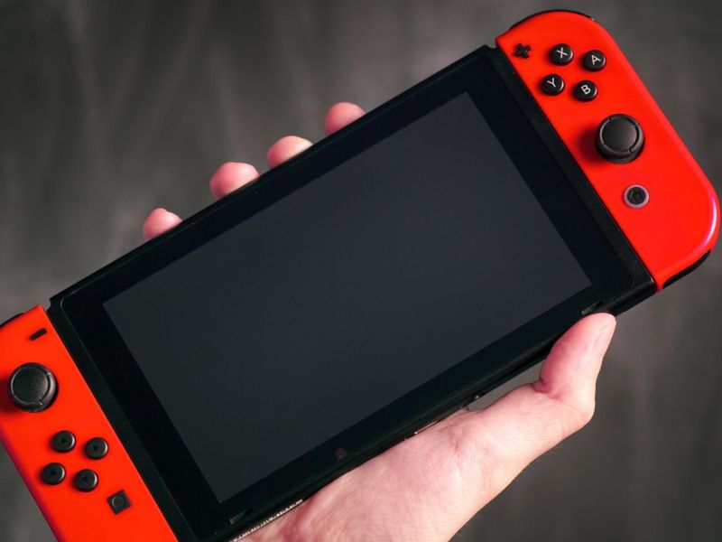 Eine Nintendo Switch in der Hand einer Person.