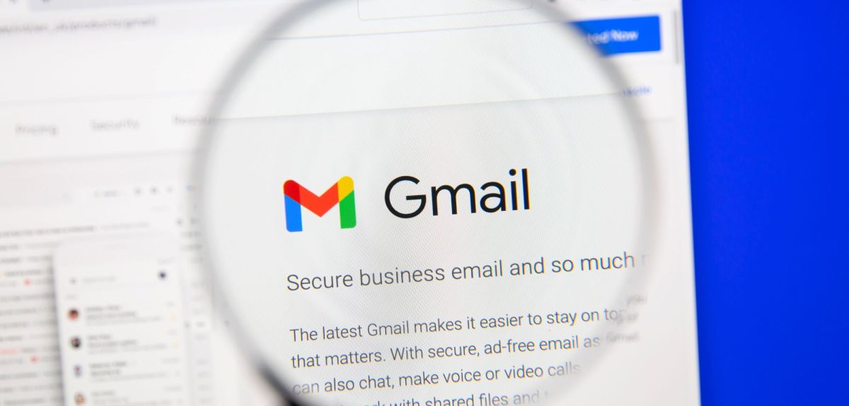 Gmail-Symbol auf einem Bildschirm unter einer Lupe.