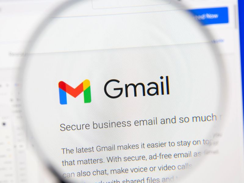 Gmail-Symbol auf einem Bildschirm unter einer Lupe.